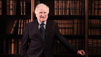 Lord Kerr in front of bookcase packed with law reports