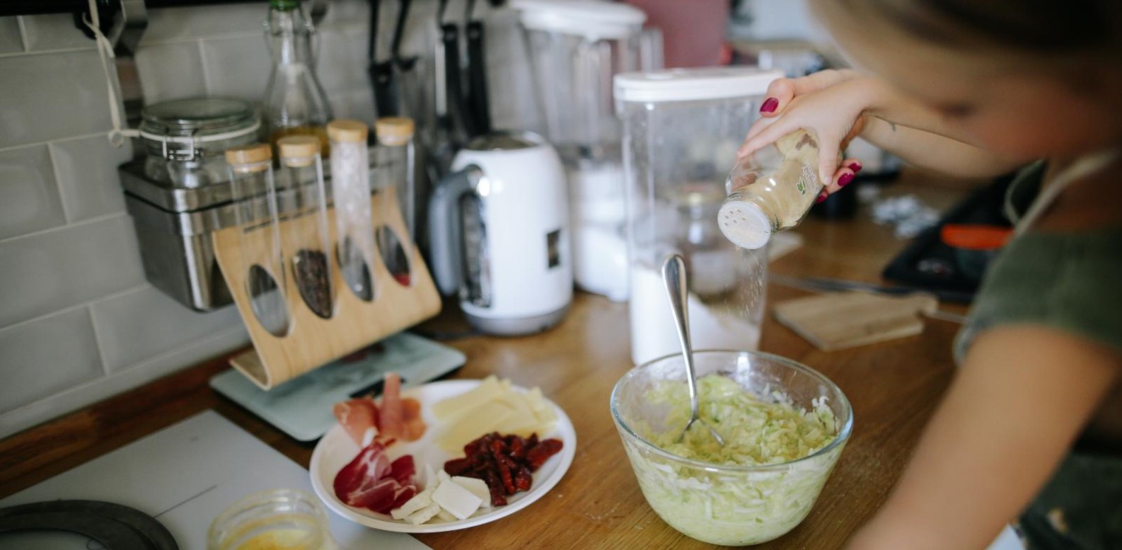 Learning to cook Young girl adding ingredients to bowl in kitchen