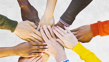 Nine hands meeting in middle to represent helping people
